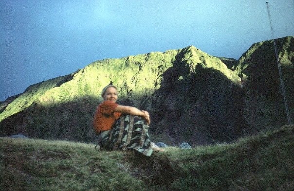My mother on a slope on Tristan with the volcanic ridge of Pigbite behind.
